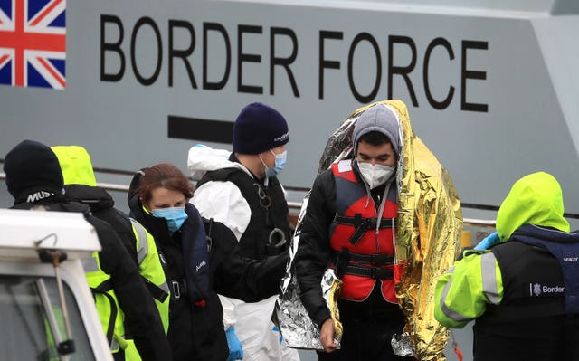 A man is helped by a Border Force officer 