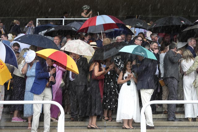 Racegoers ducking for cover at Goodwood