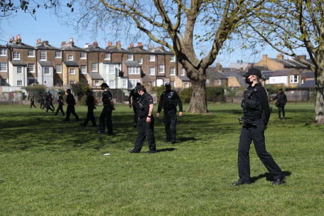 Police officers sweep the grass on the Long Walk, Windsor