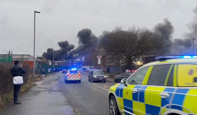 A police car near plumes of black smoke 