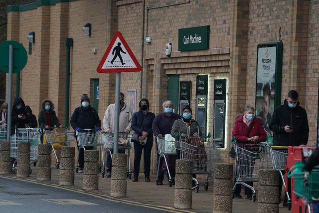 Customers queuing outside a Morrisons supermarket