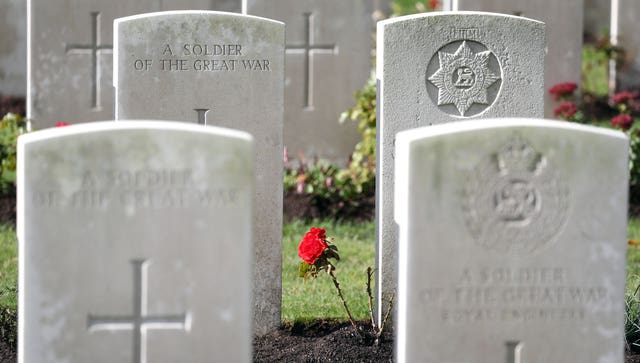 A rose grows between the headstones at the Commonwealth War Graves Commission’s Wytschaete Military Cemetery, near Ypres, Belgium (Gareth Fuller/PA)
