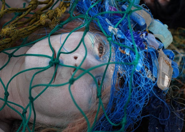 Activists from Ocean Rebellion covered in fishing nets demonstrate on the banks of the River Clyde as they ask Cop26 delegates to make bottom trawling/dredging a thing of the past 