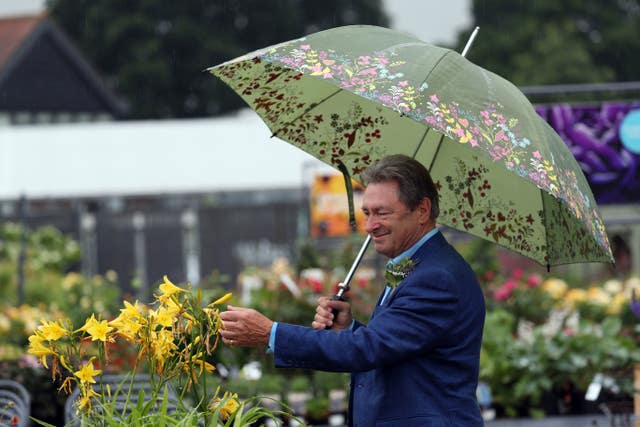 Alan Titchmarsh braves the rain for the opening of the Welcome Building at Wisley (Steve Parsons/PA)