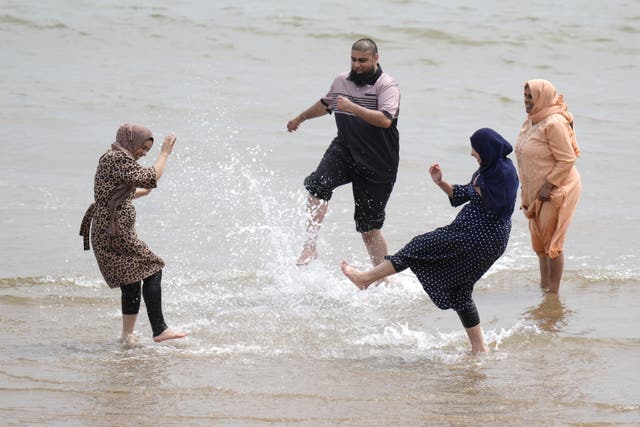 Four people splashing about and enjoying the warm weather on Scarborough beach on June 29 2024