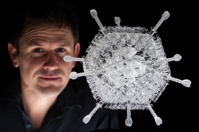 Luke Jerram pictured next to his glass sculpture of the Oxford/AstraZeneca vaccine (Andrew Matthews/PA)