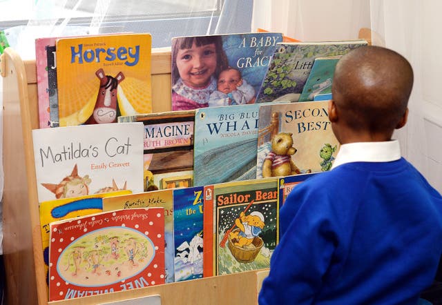 A child looking at books in a nursery