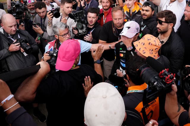 Lando Norris holds his face