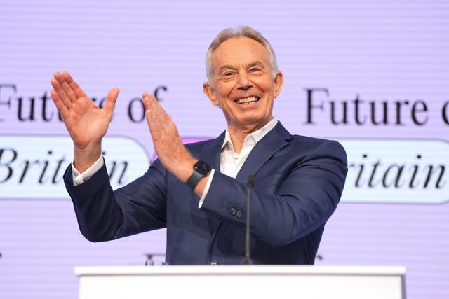 Tony Blair gestures at a podium