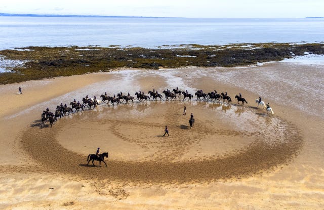 Members of the Household Cavalry, Blues and Royals, exercise their horses along the sands and in the sea at Yellowcraig Beach near North Berwick, East Lothian, after taking part earlier in the week at the Service of Thanksgiving for the King in Edinburgh 