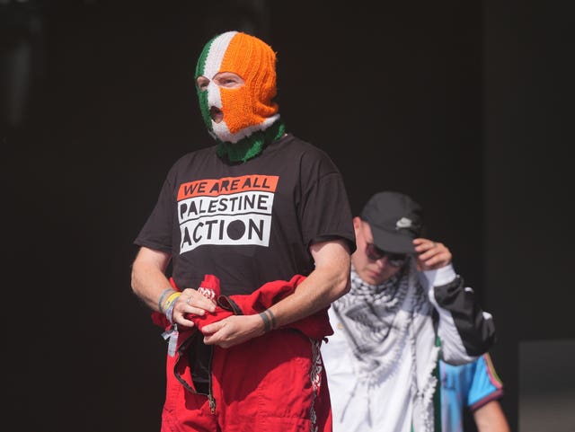 JJ O’Dochartaigh performing during Kneecap's set on the West Holts Stage in a T-shirt supporting Palestine Action