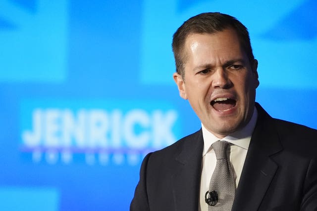 Tory leadership frontrunner Robert Jenrick  in front of a sign spelling out his surname 