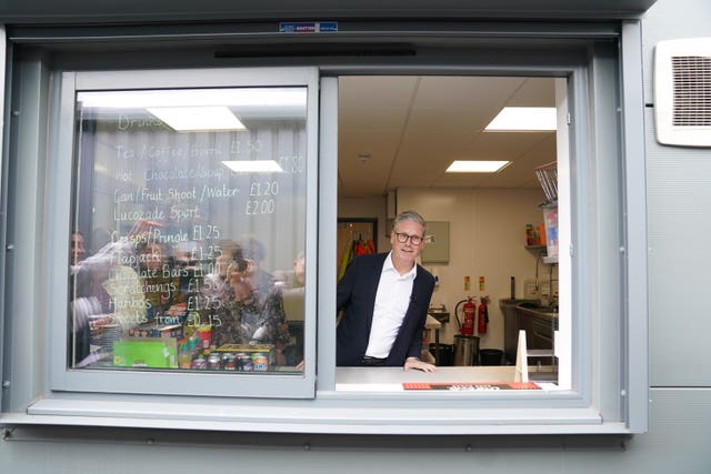 Sir Keir Starmer looking out the window of a kitchen selling drinks at Hucknall Town FC in Nottinghamshire