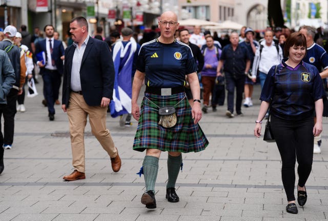 John Swinney wearing a Scotland football shirt and kilt on the streets of Bavaria