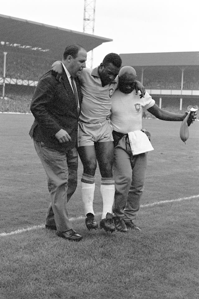 Pele is helped from the pitch by Brazil team doctor Hilton Gosling (left) and coach Americo (right) after he is injured against Portugal 