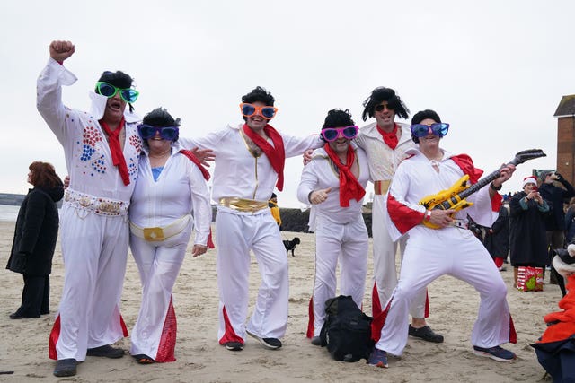 Swimmers dressed as Elvis take part in the Folkestone Lions’ Boxing Day Dip at Sunny Sands Beach in Folkestone