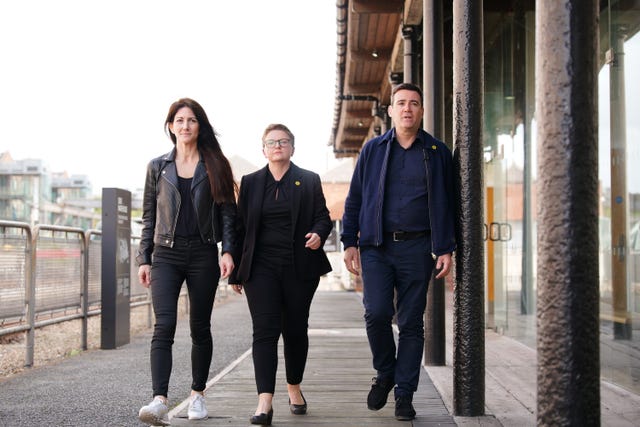 Business leader Lou Cordwell, leader of Manchester City Council Bev Craig and mayor of Greater Manchester Andy Burnham arrive for a press conference at the Museum of Science and Industry