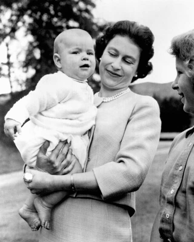 Queen Elizabeth II holding Prince Andrew during an outing in the grounds at Balmoral, Scotland in 1960 