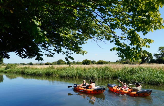 People canoe along the Chichester Canal near to Hunston in West Sussex 