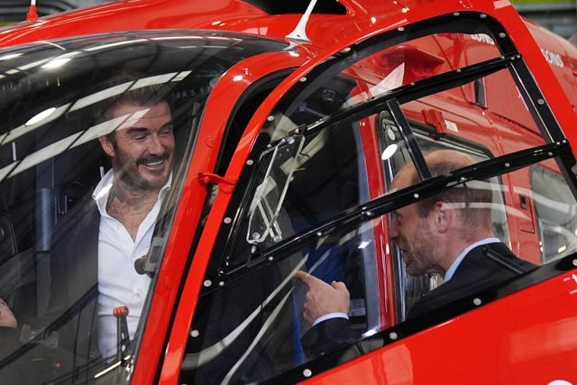 The Prince of Wales with David Beckham sitting in the cockpit of one of the new helicopters