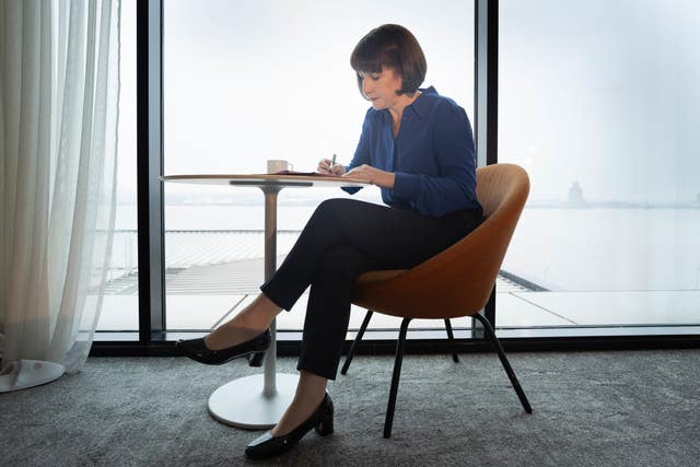 Chancellor Rachel Reeves writing while sat at a table