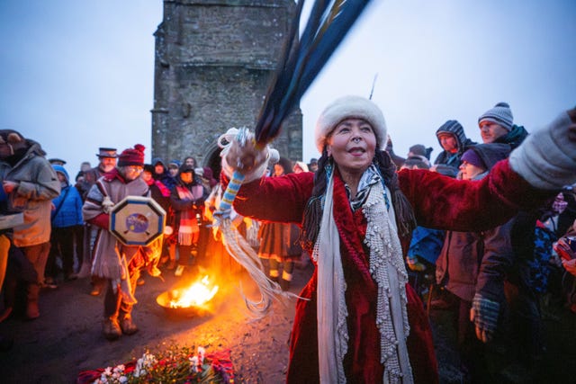 People take part in the winter solstice celebrations during sunrise at Glastonbury Tor in Somerset