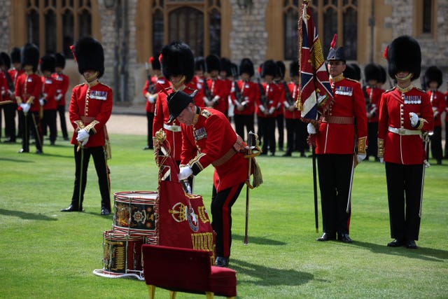 The flags being positioned on the drum stack, a makeshift altar created from regimental drums, during the ceremony