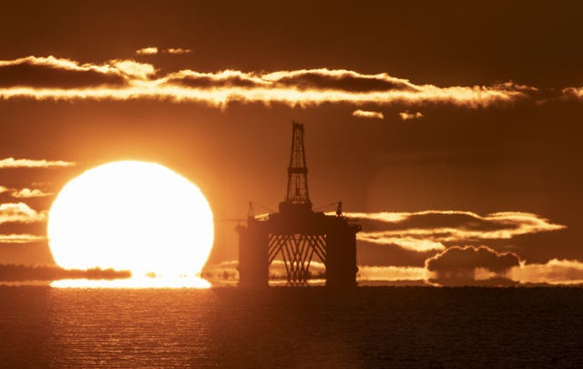 An oil platform with the sun rising beside it