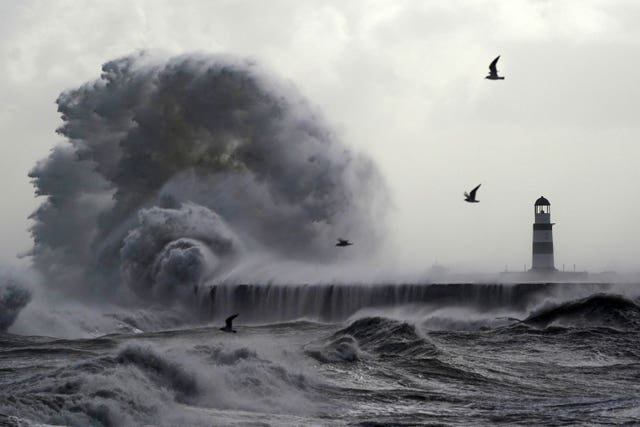 Waves crashing against the lighthouse in Seaham Harbour, County Durham