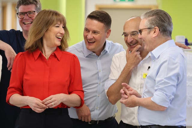 Sir Keir Starmer, Rachel Reeves and Wes Streeting laugh with doctors at a health centre in London