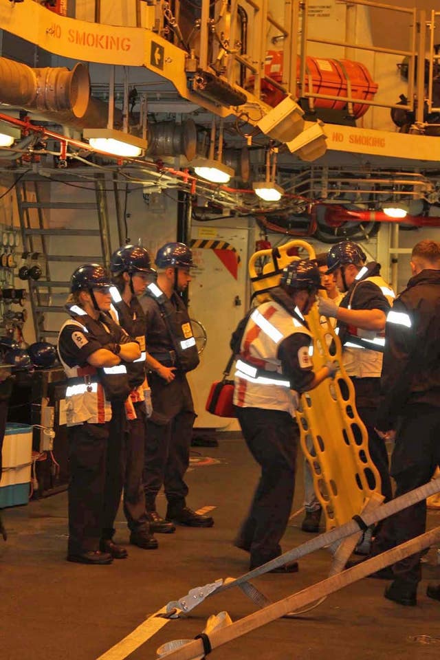 Sailors aboard HMS Diamond getting ready to launch the ship’s seaboat to help rescue people on a sinking yacht