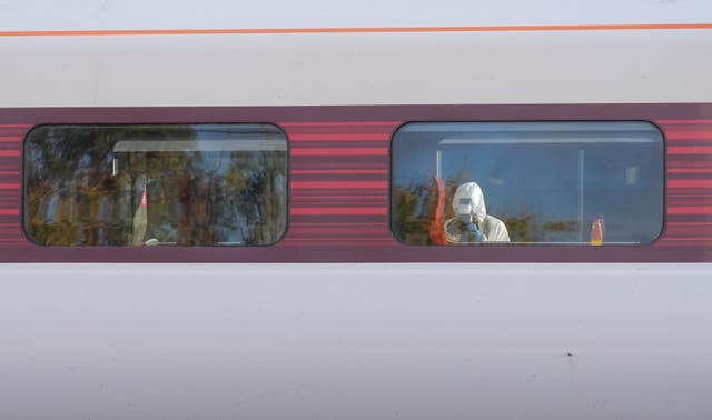 A forensic investigator photographing the scene inside the train 