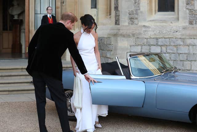 Harry helps Meghan into the car before driving to Frogmore House (Steve Parsons/PA)