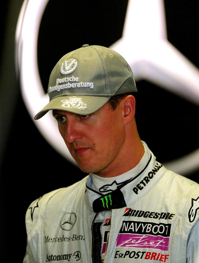 Michael Schumacher in front of a large Mercedes logo