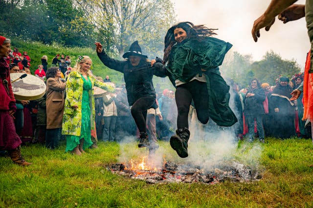 People jump the fire during the Beltane celebrations at Glastonbury Chalice Well 