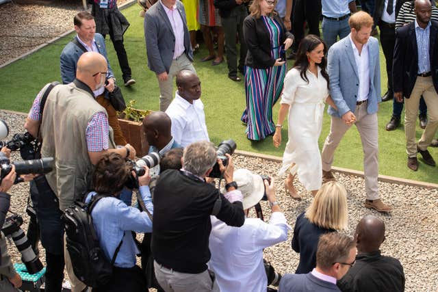 The Duke and Duchess of Sussex walk past press photographers after a visit to the Tembisa township in Johannesburg 