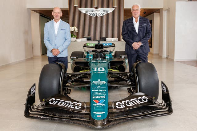 Adrian Newey (left) and Aston Martin boss Lawrence Stroll look forward while standing either side of the team's Formula One car