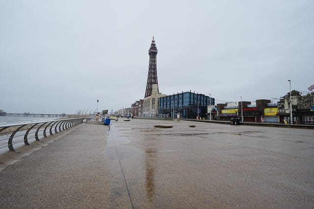 The Blackpool Tower's reflection can be seen on a wet promenade