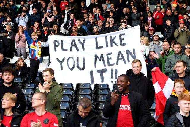 Manchester United fans hold up a sign saying ‘Play Like You Mean It!!’ before the Premier League match at Craven Cottage