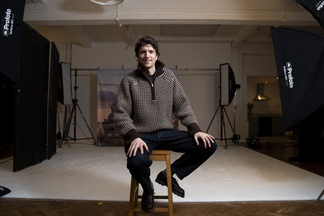 Greg James sitting on a stool in a studio