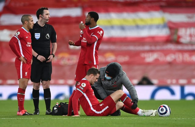 Jordan Henderson is checked by medical staff on the pitch
