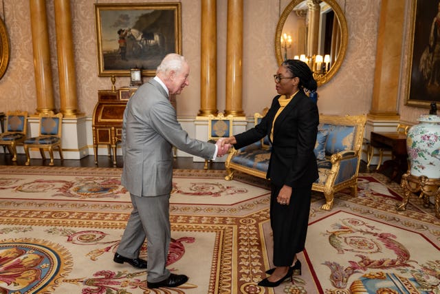 Charles and Kemi Badenoch shaking hands in the 1844 Room of Buckingham Palace