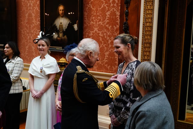 The King presents the Humanitarian Medal to Paula Tobin during a medal presentation at Buckingham Palace, London