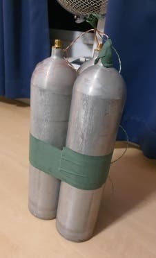 Silver coloured gas canisters held together with green tape