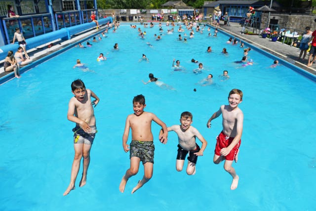 People play in the water at Hathersage Outdoor Swimming Pool in Derbyshire