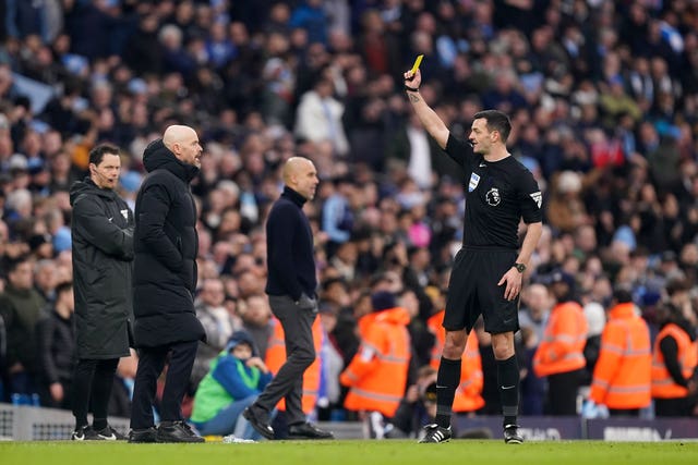 Manchester United manager Erik ten Hag (left) is shown a yellow card in the Manchester derby
