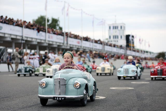 A young girl driving in a blue car with the number plate 'Issy' races in the Settrington Cup