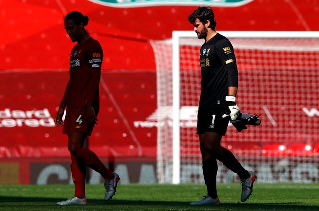 Virgil Van Dijk and Alisson Becker walk off the pitch at Anfield