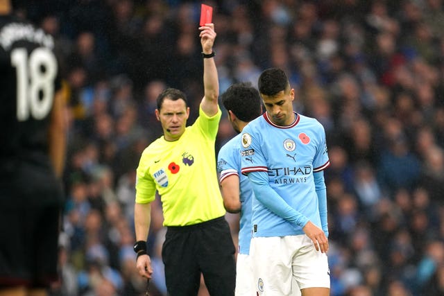 Referee Darren England shows a red card to Manchester City’s Joao Cancelo 