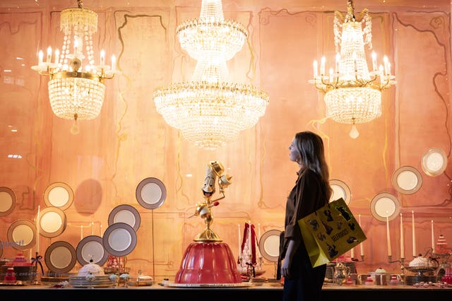 A shopper looks at a window display feature characters from Disney's Beauty And The Beast